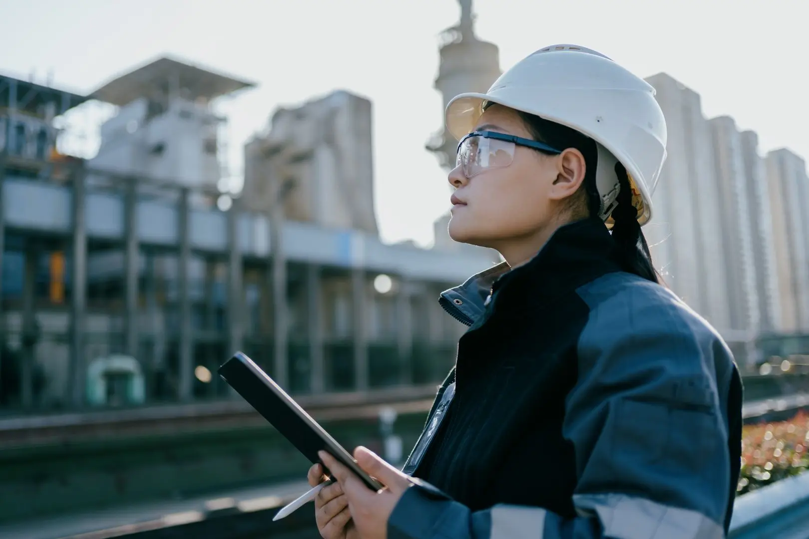 Frau mit Schutzhelm auf Industriegelände